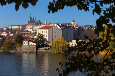 Çek Cumhuriyeti 'nin güneşli bir gününde Vltava Nehri üzerindeki Gotik Şatosu ile Sonbahar Renkli Prag Küçük Kasabası