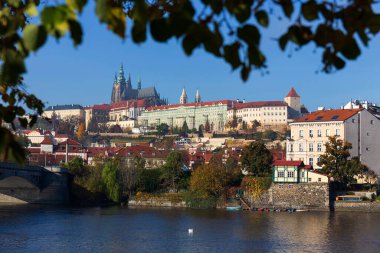 Çek Cumhuriyeti 'nin güneşli bir gününde Vltava Nehri üzerindeki Gotik Şatosu ile Sonbahar Renkli Prag Küçük Kasabası