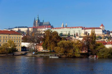 Çek Cumhuriyeti 'nin güneşli bir gününde Vltava Nehri üzerindeki Gotik Şatosu ile Sonbahar Renkli Prag Küçük Kasabası