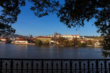 Çek Cumhuriyeti 'nin güneşli bir gününde Vltava Nehri üzerindeki Gotik Şatosu ile Sonbahar Renkli Prag Küçük Kasabası