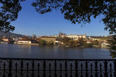 Çek Cumhuriyeti 'nin güneşli bir gününde Vltava Nehri üzerindeki Gotik Şatosu ile Sonbahar Renkli Prag Küçük Kasabası