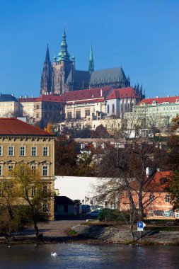 Çek Cumhuriyeti 'nin güneşli bir gününde Vltava Nehri üzerindeki Gotik Şatosu ile Sonbahar Renkli Prag Küçük Kasabası