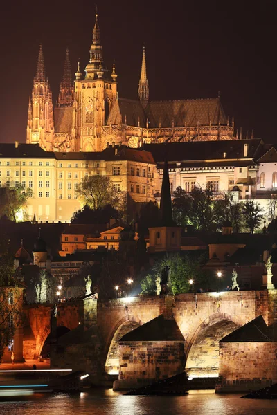 Barevné Pražský gotický hrad nad řeky Vltavy s Karlovým mostem v noci, Česká republika — Stock fotografie