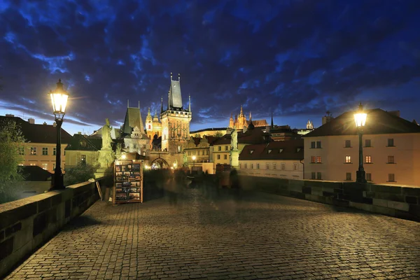 Barevné Pražský gotický hrad s katedrálou svatého Mikuláše z Karlova mostu nad řeky Vltavy v noci, Česká republika — Stock fotografie