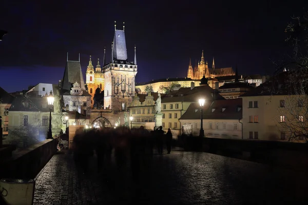 Colorido castillo gótico de Praga con la catedral de San Nicolás desde el puente de Carlos sobre el río Moldava en la noche, República Checa — Foto de Stock