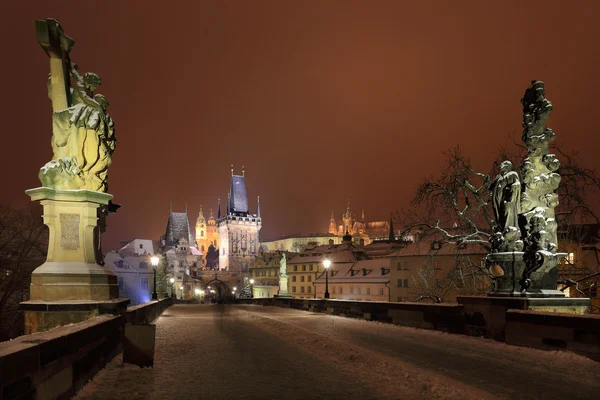 Romantische nächtliche verschneite Prager gotische Burg und Nikolauskathedrale von der Karlsbrücke, Tschechische Republik — Stockfoto