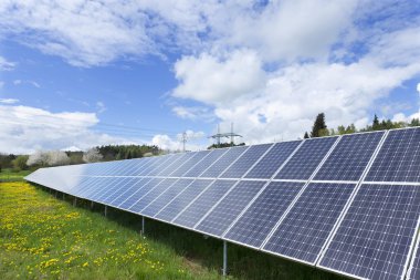 Bahar çiçekli çayırdaki güneş enerjisi santrali