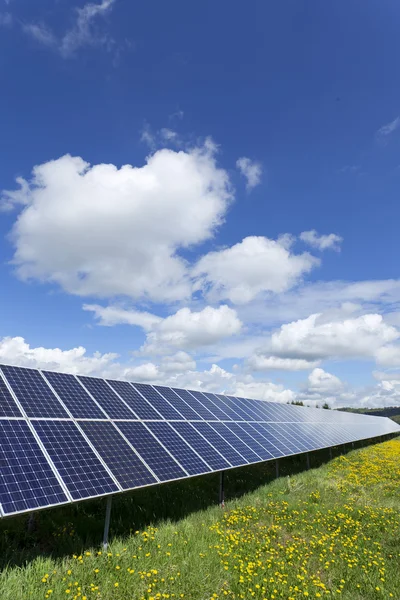 Central de energia solar no prado de floração primavera — Fotografia de Stock