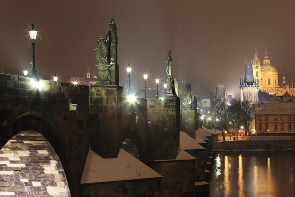 Nacht romantische besneeuwde Praag stad met Charles Bridge en St. Nicholas kathedraal, Tsjechië — Stockfoto
