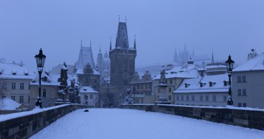 Erken sabah romantik karlı Prag Lesser Town Gotik kale, köprü kule ve Aziz Nicholas Katedrali Charles Bridge ile Barok, heykeller, Çek Cumhuriyeti ile