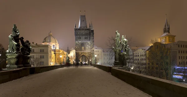 Night romantic snowy Prague Old Town with Bridge Tower and St. Francis of Assisi Cathedral from Charles Bridge with its baroque Statues, Czech republic — Stock Photo, Image