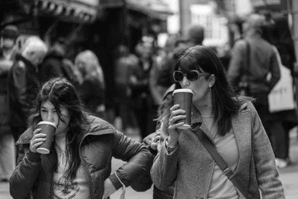 Duas Mulheres Passeando Longo Uma Rua Enquanto Bebem Café Copos — Fotografia de Stock