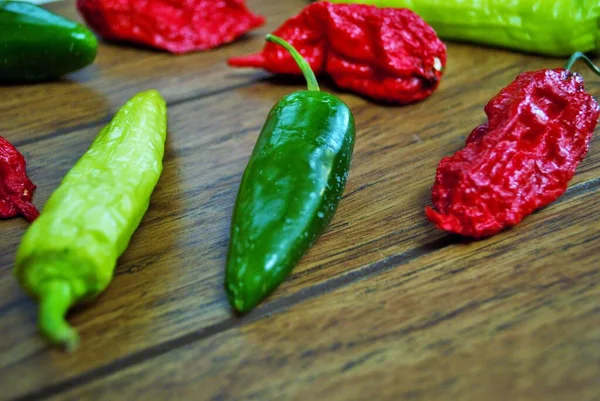 Fresh jalapeno habanero and banana pepper on a wooden background