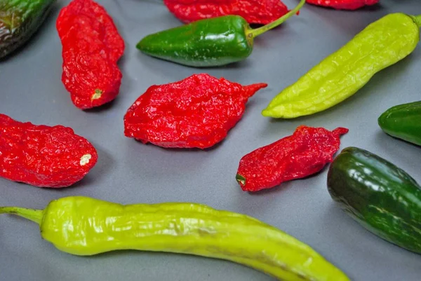 Fresh jalapeno habanero and banana pepper on a silver background