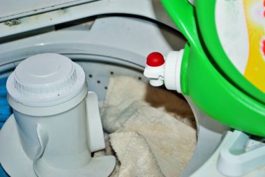 Çamaşır makinesinde çamaşır deterjanı dolu kirli havlular.