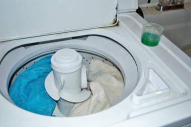 Çamaşır makinesinde çamaşır deterjanı dolu kirli havlular.