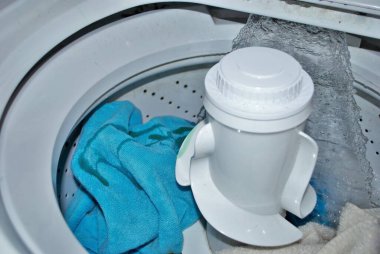 Suyla dolu bir çamaşır makinesinde kirli havlular.