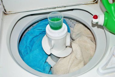 Çamaşır makinesinde çamaşır deterjanı dolu kirli havlular.