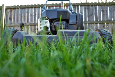 Uzun otların arasındaki çim biçme makinesinin zemin katı manzarası 