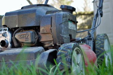 Uzun otların arasındaki çim biçme makinesinin zemin katı manzarası 