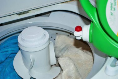 Çamaşır makinesinde çamaşır deterjanı dolu kirli havlular.