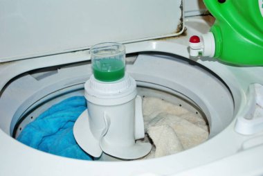 Çamaşır makinesinde çamaşır deterjanı dolu kirli havlular.