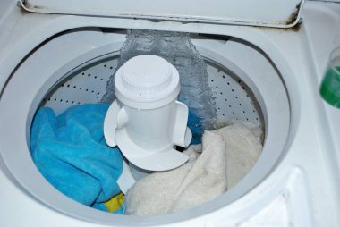 Suyla dolu bir çamaşır makinesinde kirli havlular.