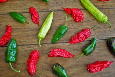Taze jalapeno habanero ve ahşap arka planda muz biberi.