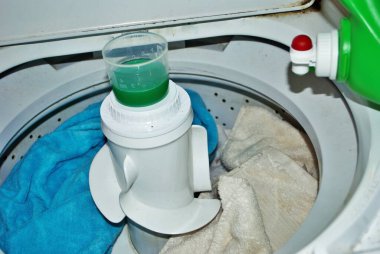 Çamaşır makinesinde çamaşır deterjanı dolu kirli havlular.
