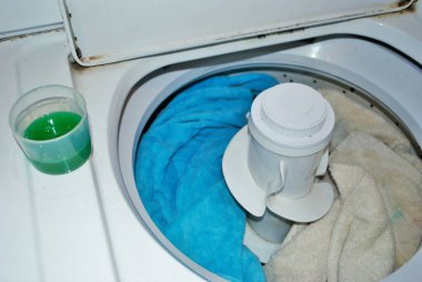 Çamaşır makinesinde çamaşır deterjanı dolu kirli havlular.