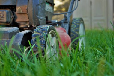 Uzun otların arasındaki çim biçme makinesinin zemin katı manzarası
