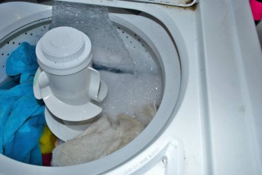 Suyla dolu bir çamaşır makinesinde kirli havlular.