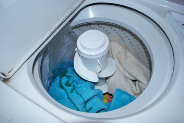 Suyla dolu bir çamaşır makinesinde kirli havlular.