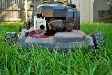 Uzun otların arasındaki çim biçme makinesinin zemin katı manzarası