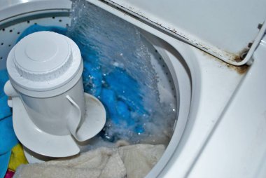 Suyla dolu bir çamaşır makinesinde kirli havlular.