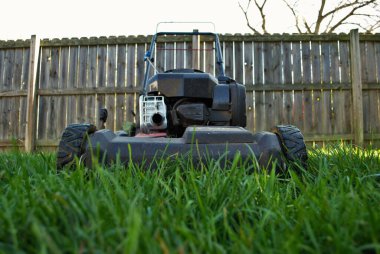 Uzun otların arasındaki çim biçme makinesinin zemin katı manzarası