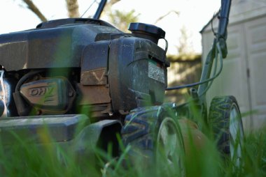 Uzun otların arasındaki çim biçme makinesinin zemin katı manzarası