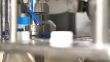 Taşıma makinesinde süt ürünleriyle dolu plastik şişelerin kapakları.