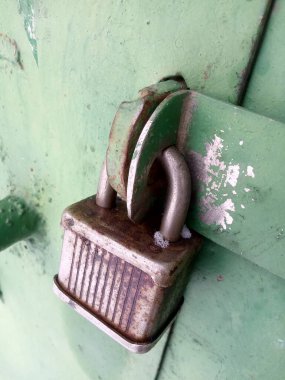 Metal bir kapının üzerinde eski paslı bir kilit. 