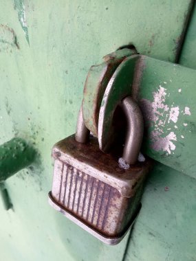 Metal bir kapının üzerinde eski paslı bir kilit. 