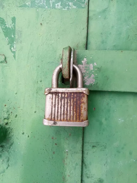 Metal bir kapının üzerinde eski paslı bir kilit. 