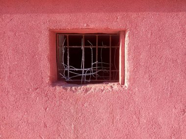 Eski kırık paslı pencere ve kırmızı duvar