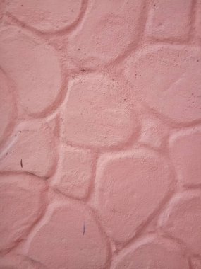 Büyük taşlarda pembe beton duvar, alçı arka plan.