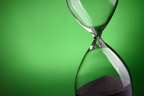 Close-up hourglass on green background — Stock Photo, Image