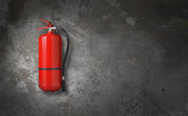 Fire extinguisher on gray wall — Stock Photo, Image