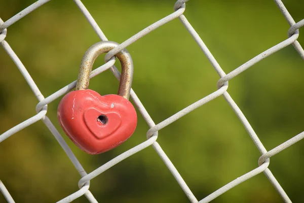 Belo cadeado vermelho em forma de coração bloqueado na corrente de ferro — Fotografia de Stock