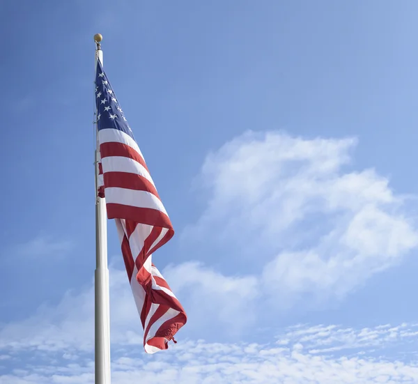 Drapeau américain sur le poteau contre le ciel bleu et les nuages — Photo