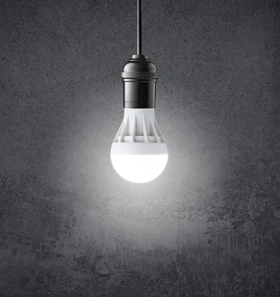 Glowing LED bulb on grunge wall — Stock Photo, Image