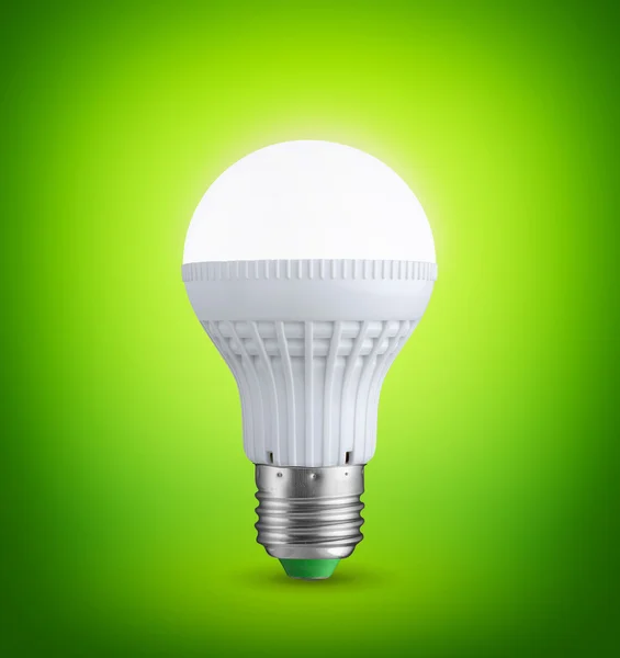 Сяюча лампочка на зеленому фоні — стокове фото