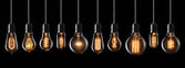 Set of vintage glowing light bulbs on black background